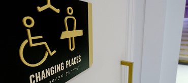 An image of a Changing Places sign outside of a toilet.