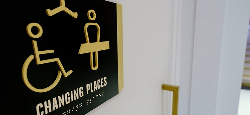 An image of a Changing Places sign outside of a toilet.