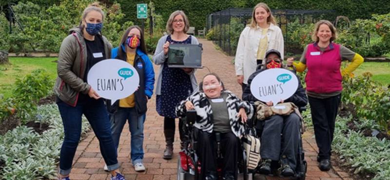 Image of everyone at the event outside in the garden including a laptop with people joining remotely.