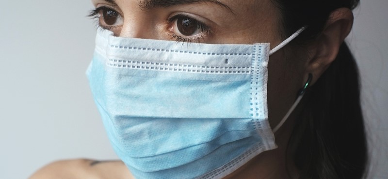 Picture of a girls face facing the camera wearing a blue mask 