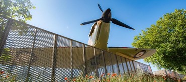 A picture of a model plane taken from underneath with the blue sky above