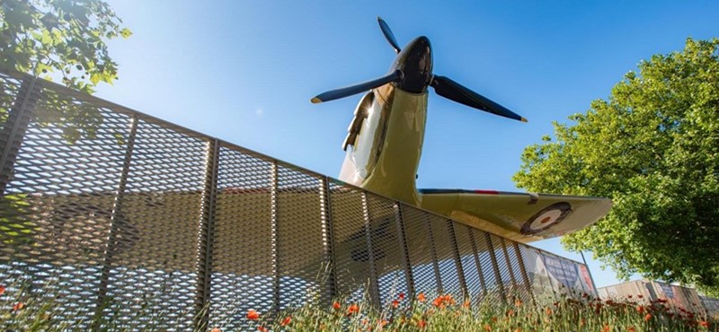 A picture of a model plane taken from underneath with the blue sky above