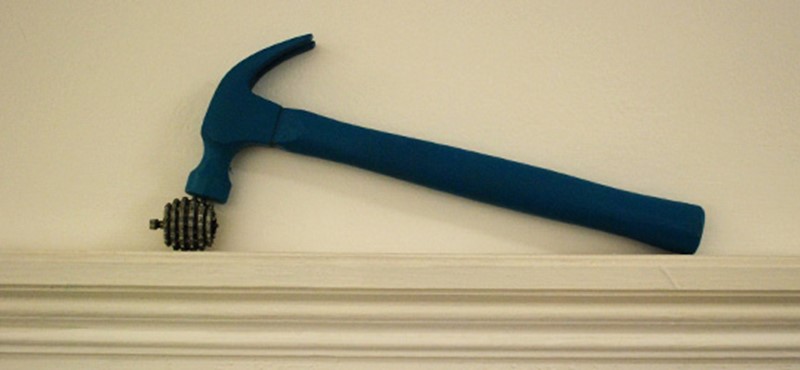 A photo of a hammer on a wall. 