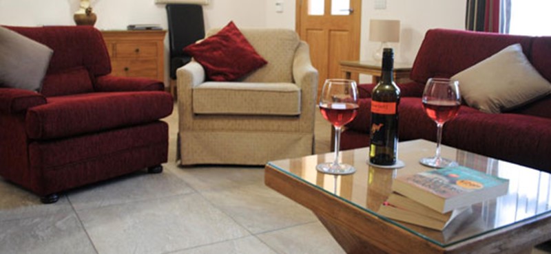 A photo of a living room with a bottle of wine on the table. 