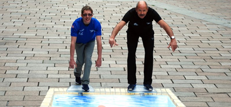 A photo of Scott Quin and David Wilkie by a photo of a pool. 