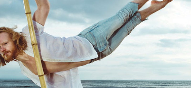 Photo of a man dancing on a beach.