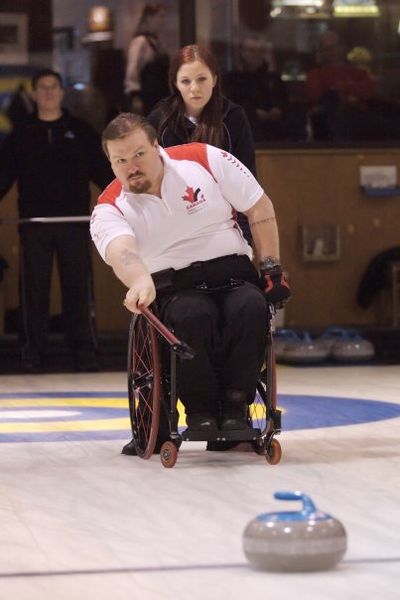 A photo of a man curling from his wheelchair.