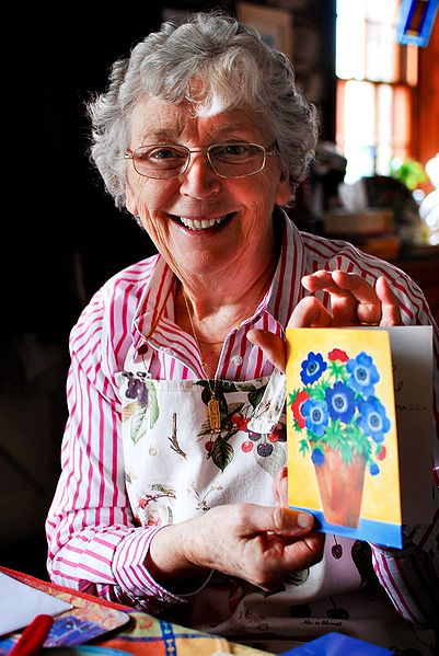 A photo of a woman holding a Mother's Day card.