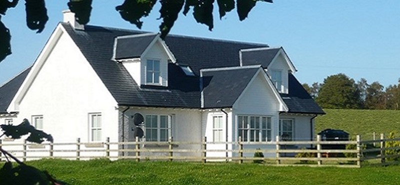 Photo of a white cottage.