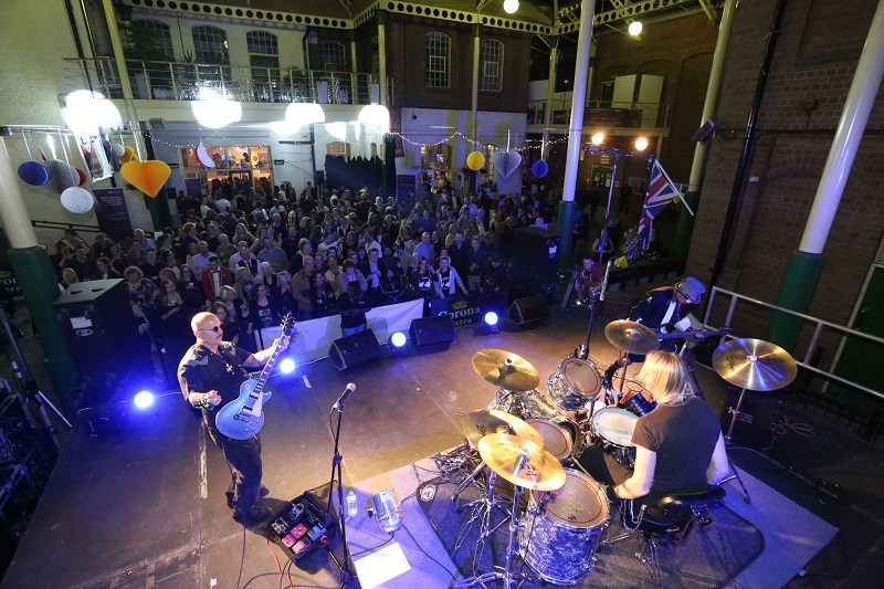 Photo of a musician playing in front of a crowd.