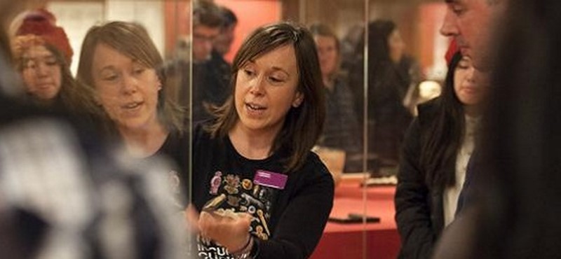 Photo of a lady leading a museum tour.