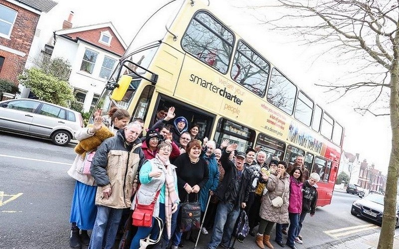 Photo of a bus and a group of people.