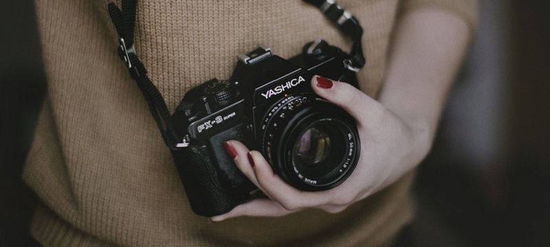 Photo of a girl holding a camera.