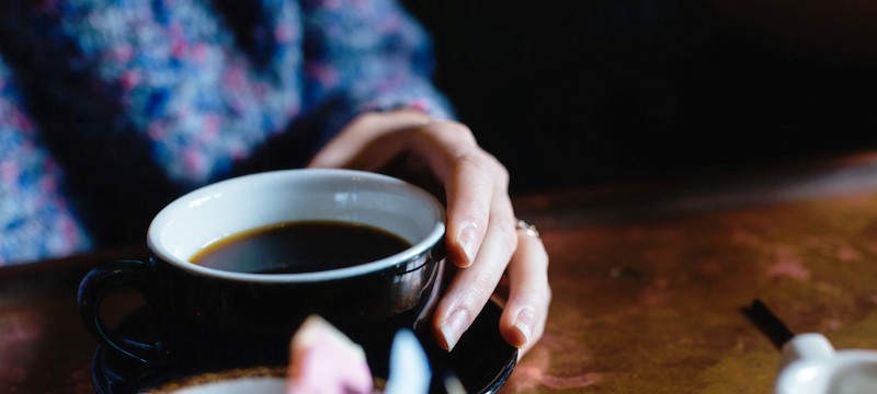 Photo of somebody holding a cup of coffee.