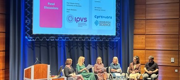 Photo from the EICC Impact Network launch event. A panel of five speakers - four female-presenting and one male-presenting—are seated on a brightly lit stage during a discussion. Panelists include Professor Sheila Graham (University of Glasgow), Professor Sharon Hanley (University of Aberdeen), Gayle McGuinn (EICC), Sophie Bell (Cyrenians), and Bill Addison (Edinburgh Science).