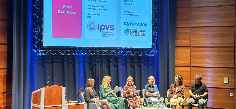 Photo from the EICC Impact Network launch event. A panel of five speakers - four female-presenting and one male-presenting—are seated on a brightly lit stage during a discussion. Panelists include Professor Sheila Graham (University of Glasgow), Professor Sharon Hanley (University of Aberdeen), Gayle McGuinn (EICC), Sophie Bell (Cyrenians), and Bill Addison (Edinburgh Science).