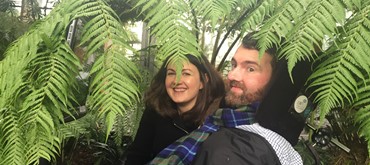 A photograph of Kiki and Euan in the Botanic Gardens at Kingsbarnes with plants all around them.