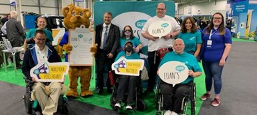 A photograph of the Euan's Guide staff and volunteers with Motability Operations CEO and mascot Billy the Bear
