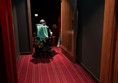 Image of a person on a powerchair entering a cinema screening room