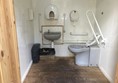 Disabled toilet in wooden hut.