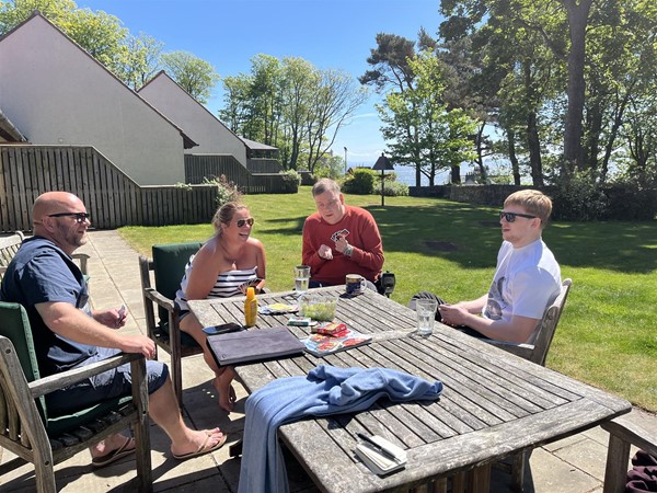 Image of people at a table in a garden.
