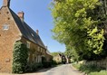 Image of a road with houses on one side and trees on the other