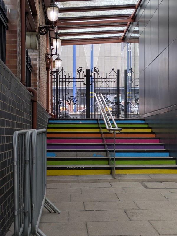 Image of stairs at the station, there's a rail in the centre