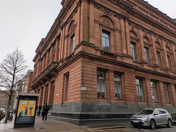 Image of of the library from the side, a large sand stone building