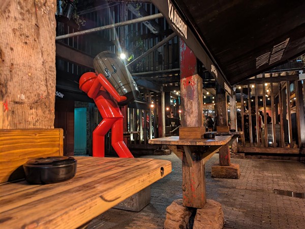 Image of courtyard, with shelves a red statue of a man mid-sprint
