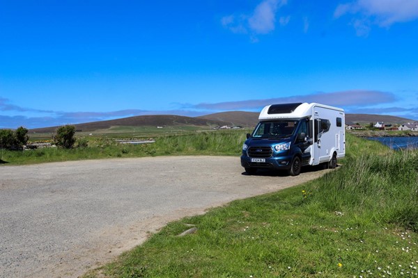 Car park with no spaces marked and just a motorhome parked up.