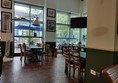 Part of the interior of the restaurant - tables, chairs, windows, a gigantic anglepoise lamp