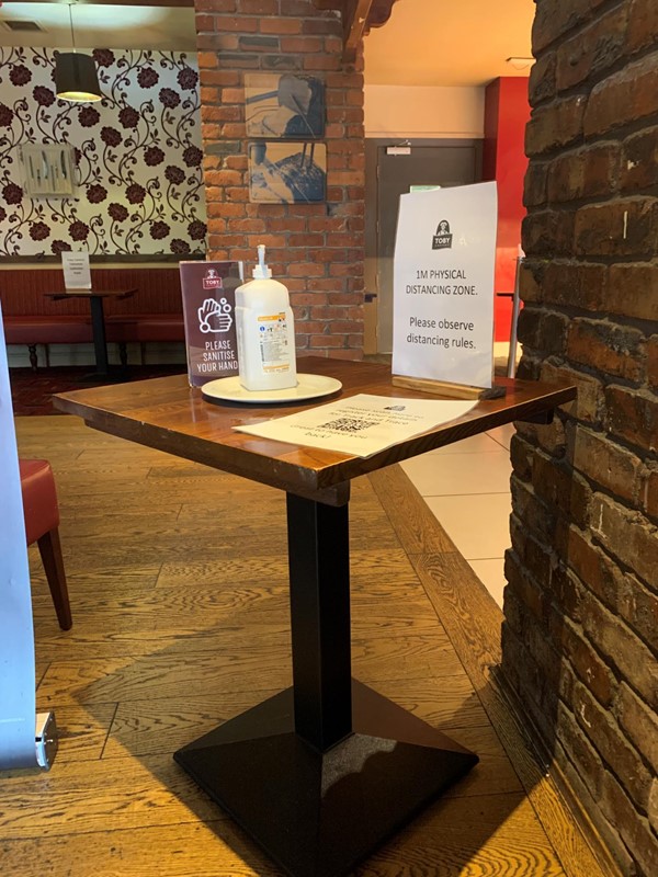 Image of table in waiting area that has hand sanitiser.