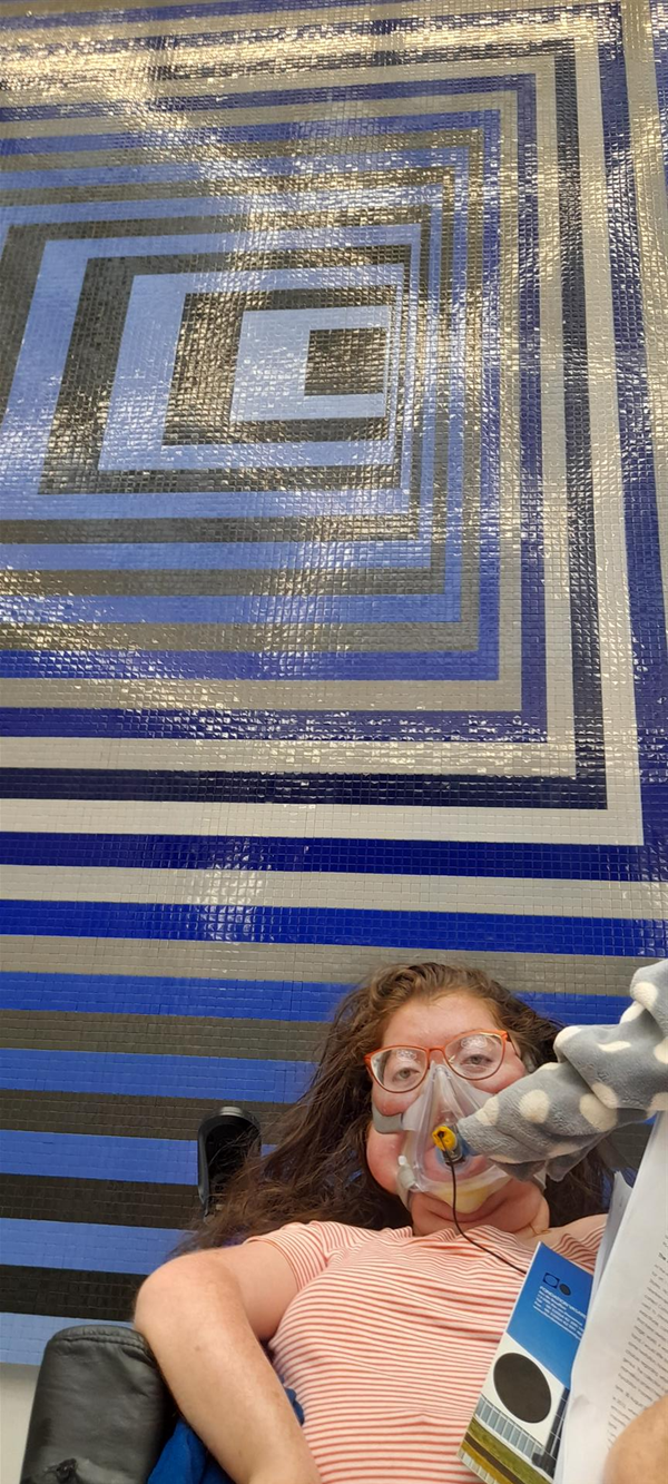 Image of a person in front of a mosaic