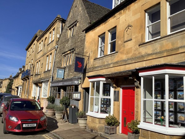 there by is a lovely honey coloured row of Cotswold houses and shops