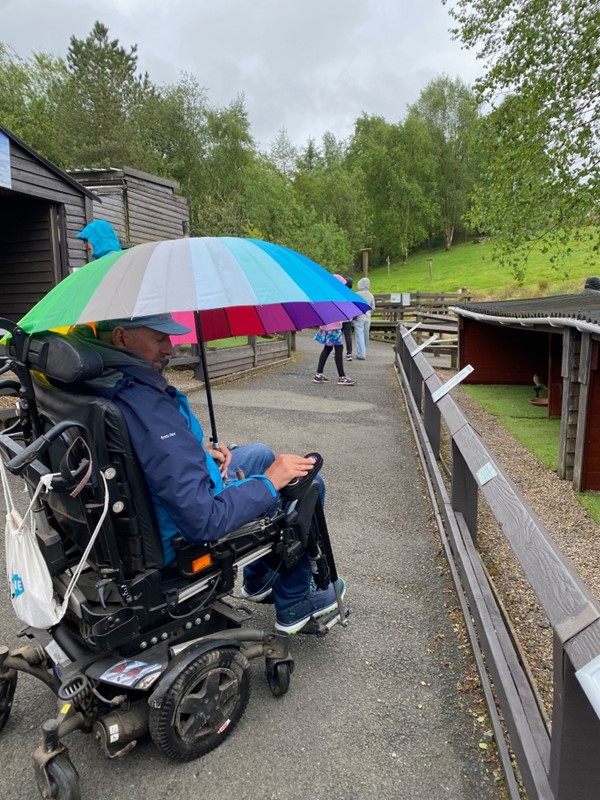 Image of a wheelchair user with an umbrella