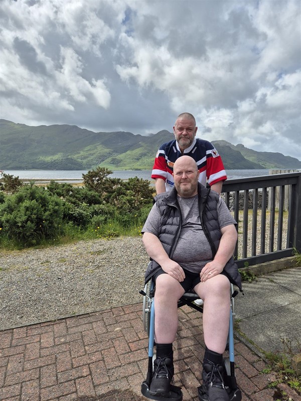Image of two people in front of a mountain