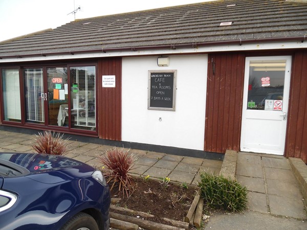 Picture of Winchelsea Beach Cafe - This shows the main use door during winter, but in the summer they have tables outside by the wider door. May not look too endearing, but the staff well make up for the looks.