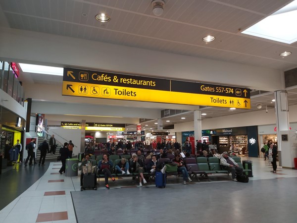 Image of sign in Airport pointing to cafes & restaurants, gates and toilets.