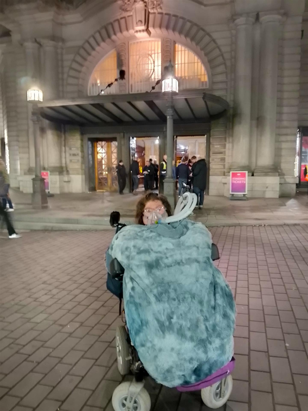 Image of a person in a wheelchair outside of a building
