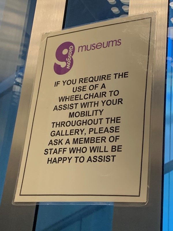 Sign in lift saying if you need a wheelchair or assistance throughout the museum just ask a member of staff