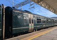 Image of of dark teal train on the platform