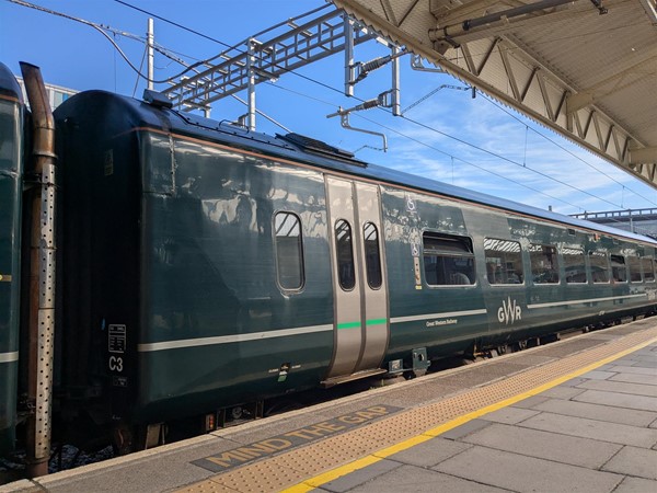 Image of of dark teal train on the platform