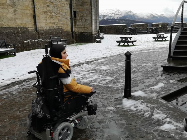 Wheelchair user driving over cobblestones.