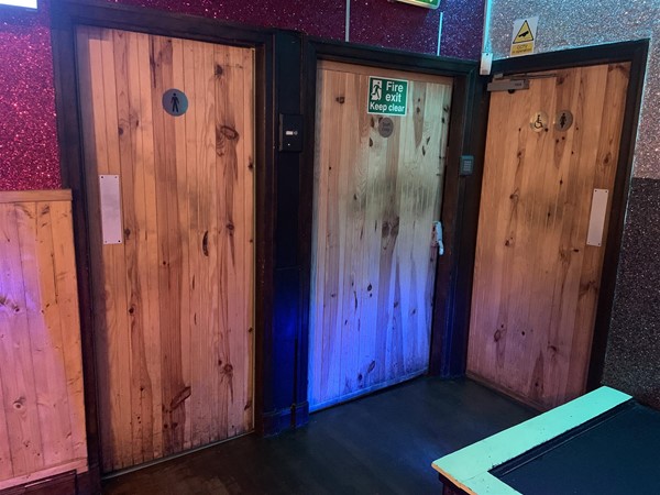 Image of two toilet doors and a fire exit