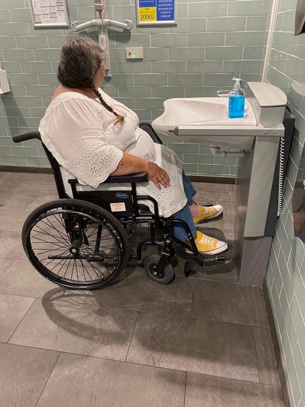 Picture of a wheelchair user in front of a height adjustable basin