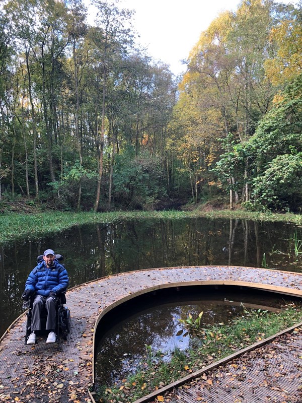 A power chair user on a path across the pond.