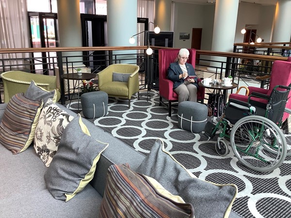 Person having tea opposite a wheelchair
