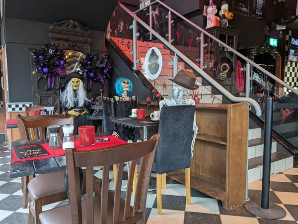 Image of seating area, some of the seats have plastic skeletons sitting in them