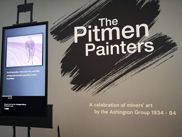 Shows the outside of the Pitman Painters exhibition with a subtitled video explaing the story of the Pitman Painters