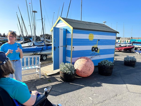 At the beach hut with Bryony Beach Wheelchairs volunteer